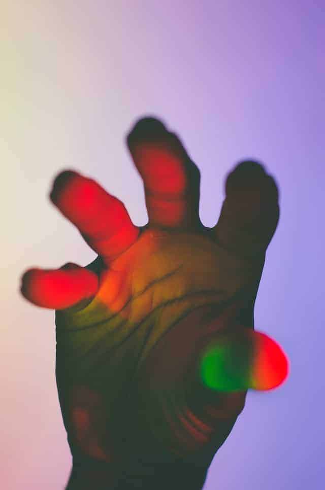 een hand in gekleurd licht