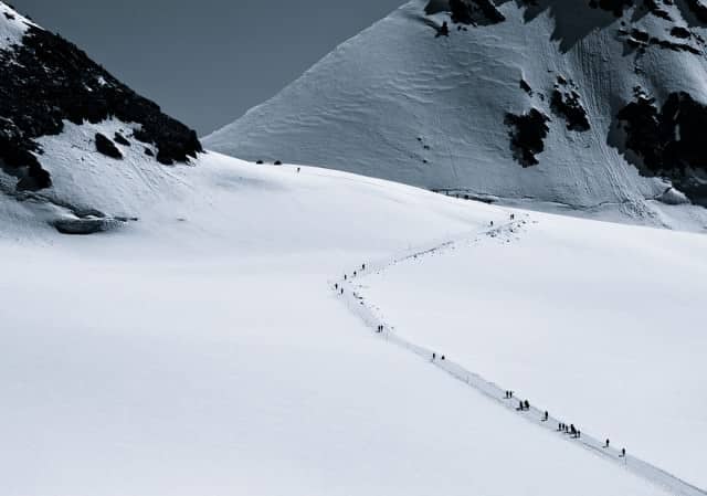 Prachtige foto van wandelaars op besneeuwde bergen